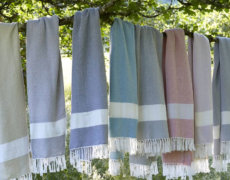 Miljøvenlige tæpper af plastik hænger på træ uden for.