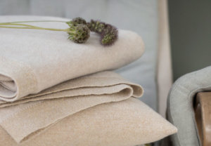 Tæpper og puder i natur farver i træstol