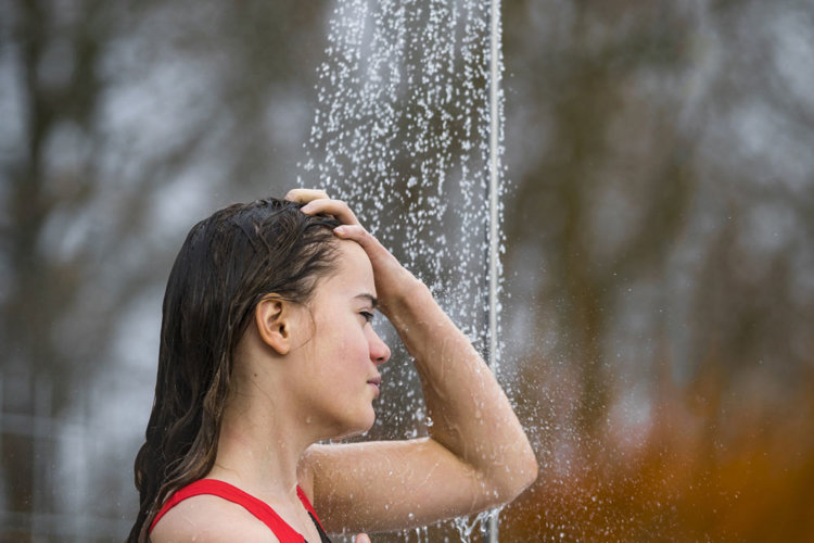 Kvinde tager et friluftsbad i sit ude-badeværelse